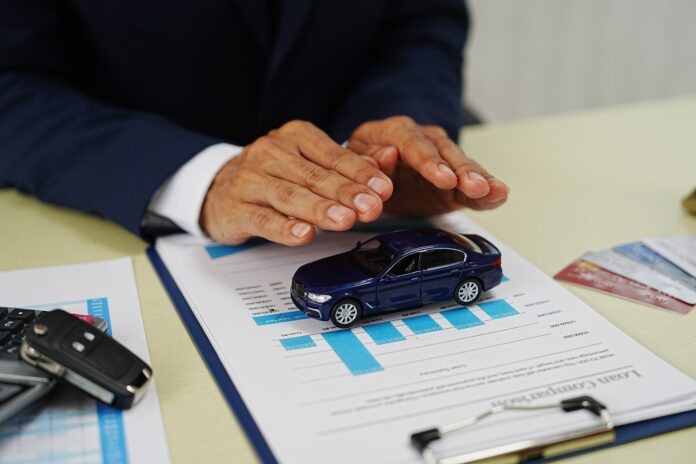 Liikluskindlustuse kehtivuse kontrollimine - mehe peopesad kaitsevad mudelautot