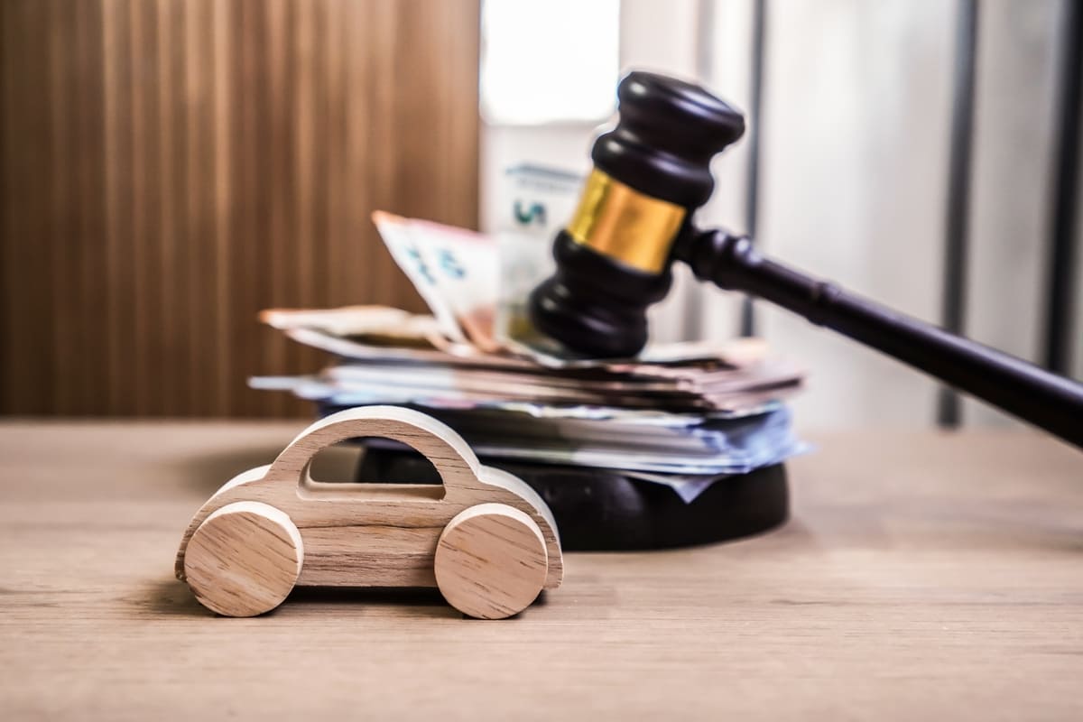 Liikluskindlustus talvel seisvale autole - mudelauto, rahatähed ja kohtuhaamer