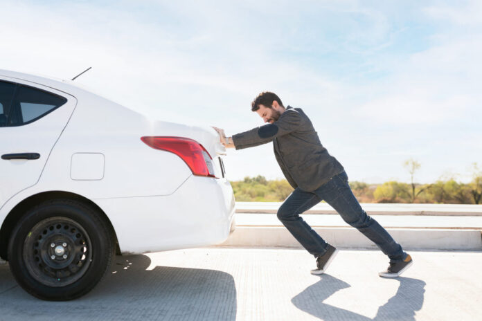 Ajutine kustutamine liiklusregistrist - mees lükkab autot pildilt välja