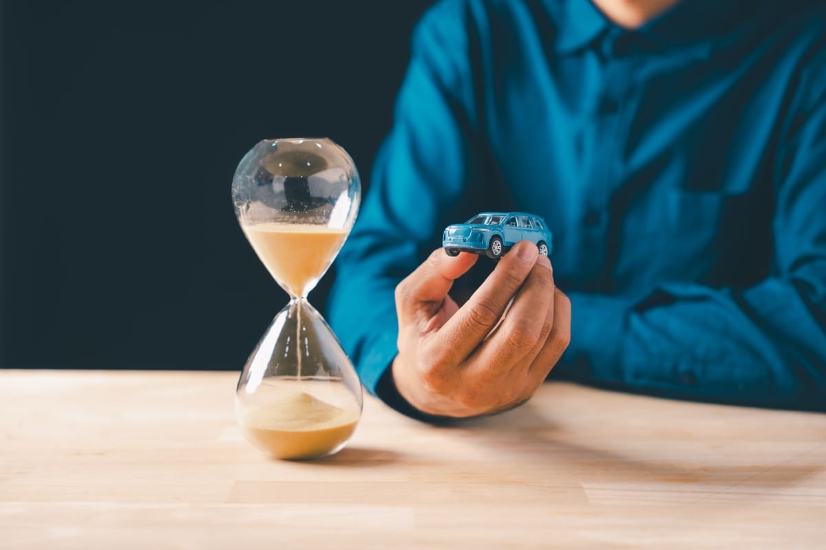 Liikluskindlustus üheks päevaks - sinine mudelauto ja tühjaks jooksev liivakell