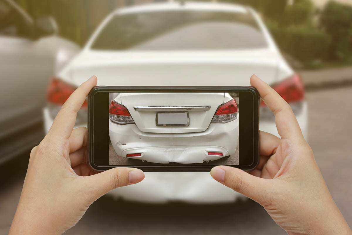 Liikluskindlustuse puudumine - katkise valge auto pildistamine mobiiliga